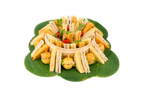 Méli-mélo de finger - 24 et 56 pièces grande version présenté sur feuilles de bananiers en 4 variétés : Saumon fumé, Jambon de pays, Briochette en crabe, Brunoise de légumes