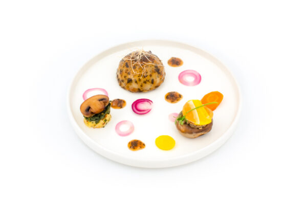 Assiette contenant un dôme de volaille confite au foie gras et avec une sauce à l'estragon. Menu - Quartz
