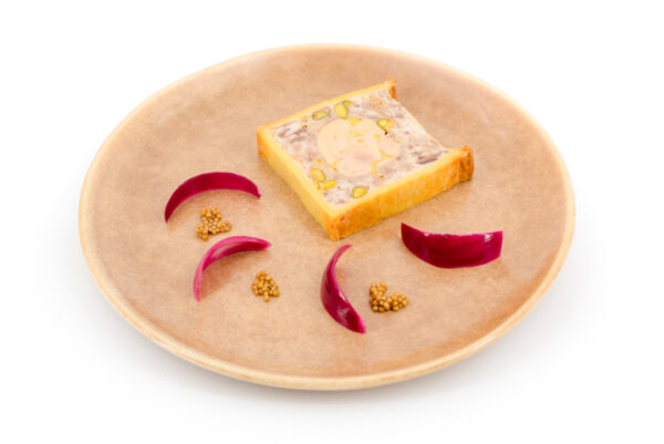 Assiette contenant une tranche de pâté en croute au poulet canard pistache et foie gras.
