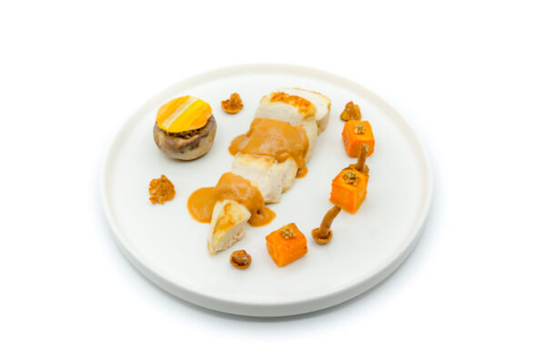 Assiette blanche contenant un suprême de volaille avec une sauce aux girolles. menu - Agate