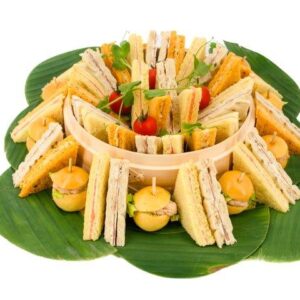 Méli Mélo de finger grande version présenté sur feuilles de bananiers en 4 variétés : Saumon fumé, Jambon de pays, Briochette en crabe, Brunoise de légumes