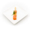 Mini brochette de saumon à l'aneth présentée sur une petite assiette carrée en porcelaine blanche