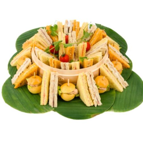 Méli-mélo de finger - 24 et 56 pièces grande version présenté sur feuilles de bananiers en 4 variétés : Saumon fumé, Jambon de pays, Briochette en crabe, Brunoise de légumes