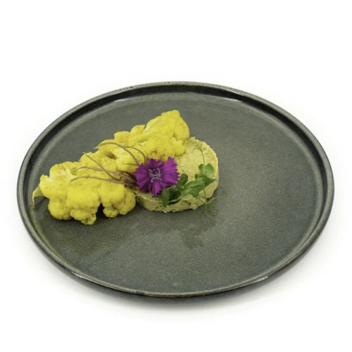 Chou-fleur rôti à la marocaine et houmous de poireaux dans une assiette sur fond blanc