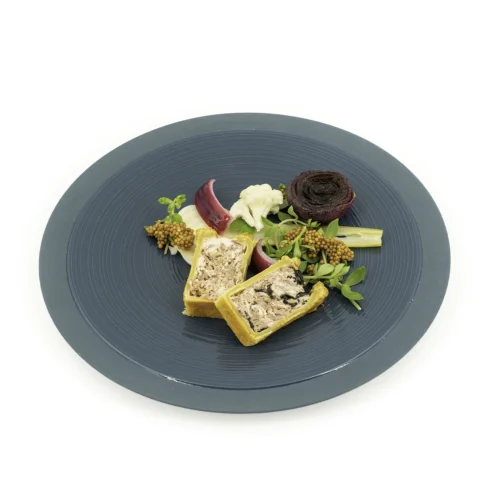 Duo de pâté en croute dans une assiette verte sur fond blanc