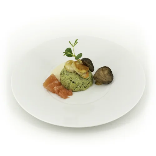 Soufflé de Saint-Jacques et cresson dans une assiette sur fond blanc