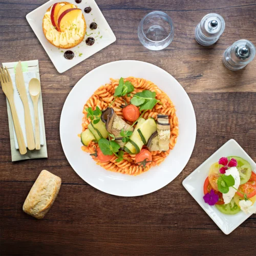 Plateaux repas Amérique 2026, Tomates en rosace, crème de chèvre, pasta au pesto rosso, baba pêche agrumes.