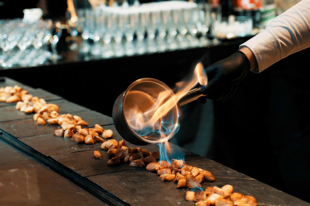Calamar flambé pendant une réception.