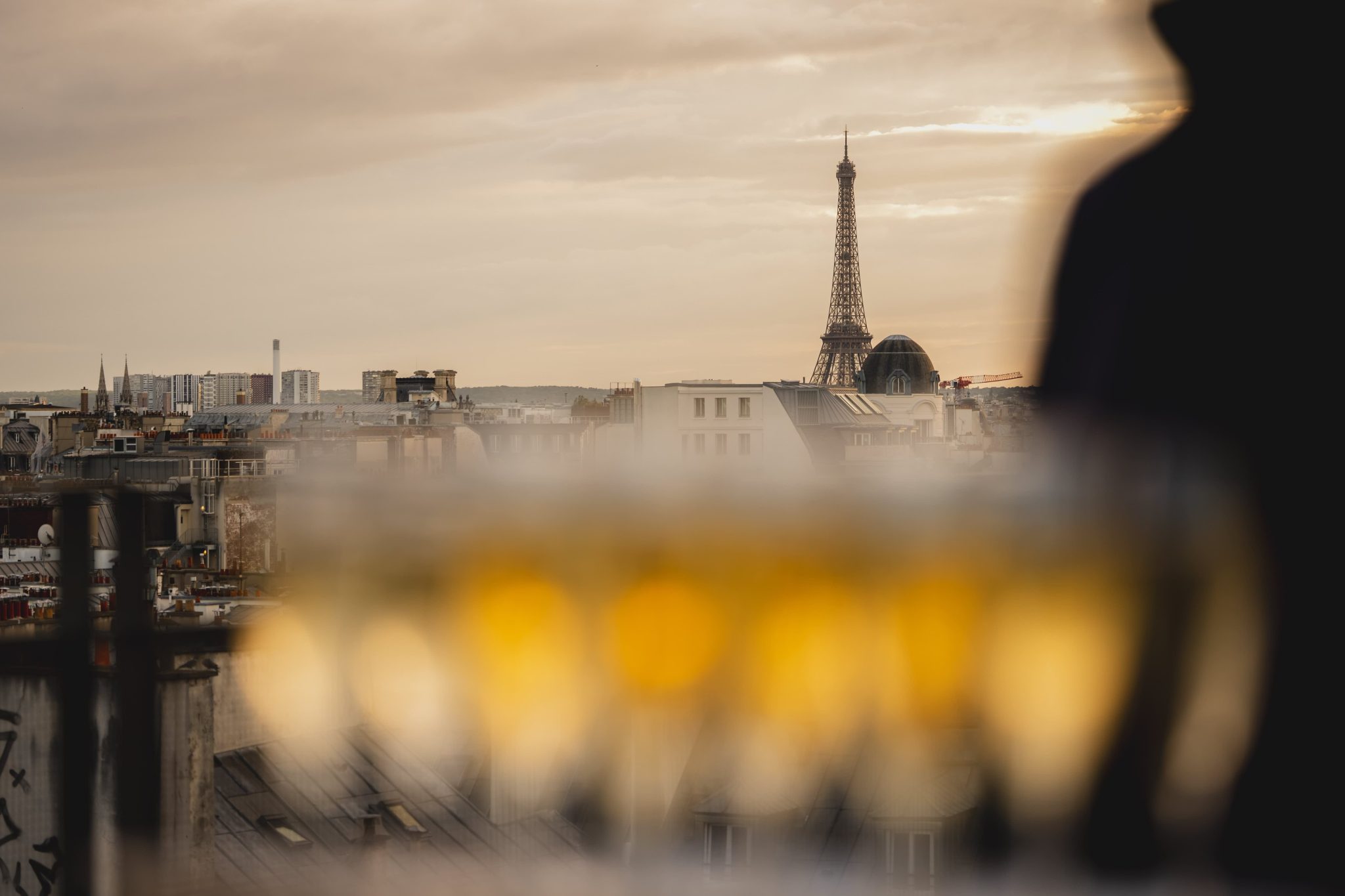 Flou sur un plateau a=de flûtes de champagne avec une vue sur la tour Eiffel dans le fond.