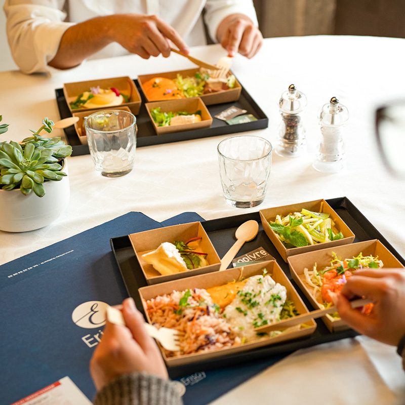 Repas en tête à tête entre deux personnes avec des plateaux repas RISAY Réceptions encore dans leurs emballages.