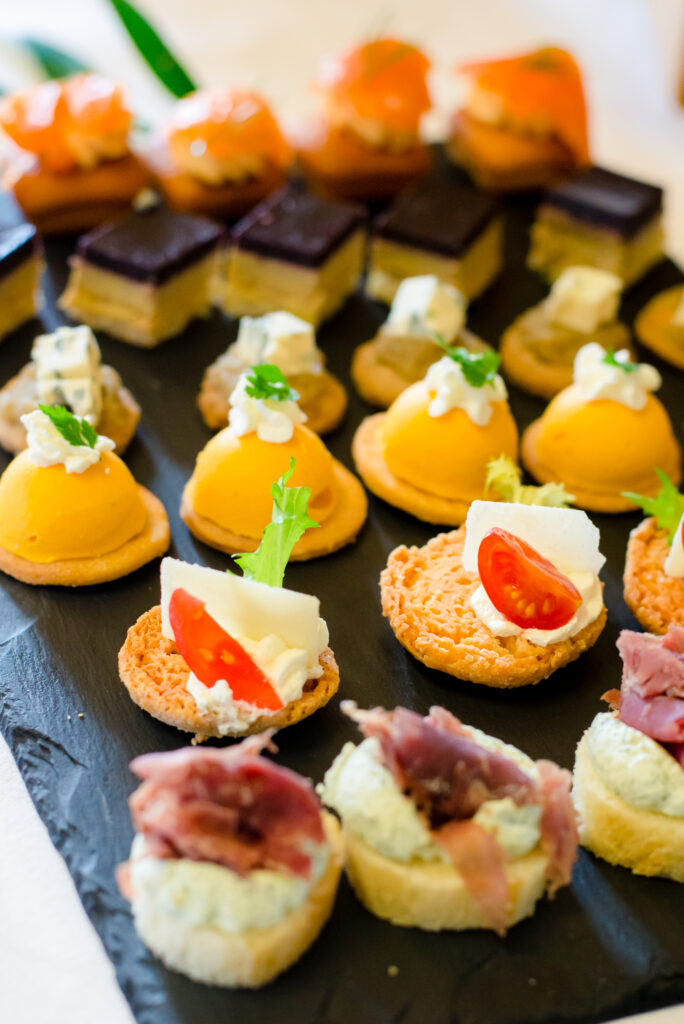 Variété de pièces cocktails sur un plateau en ardoise.