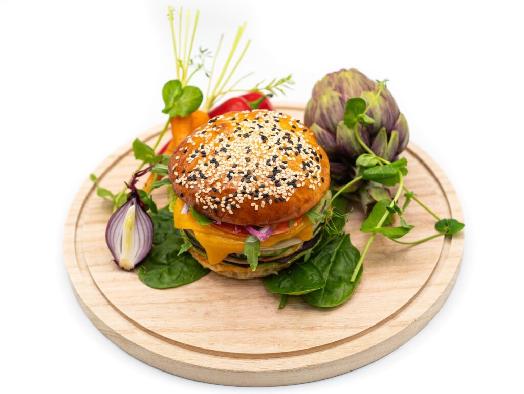 Burger végétarien sur un plateau circulaire en bois.