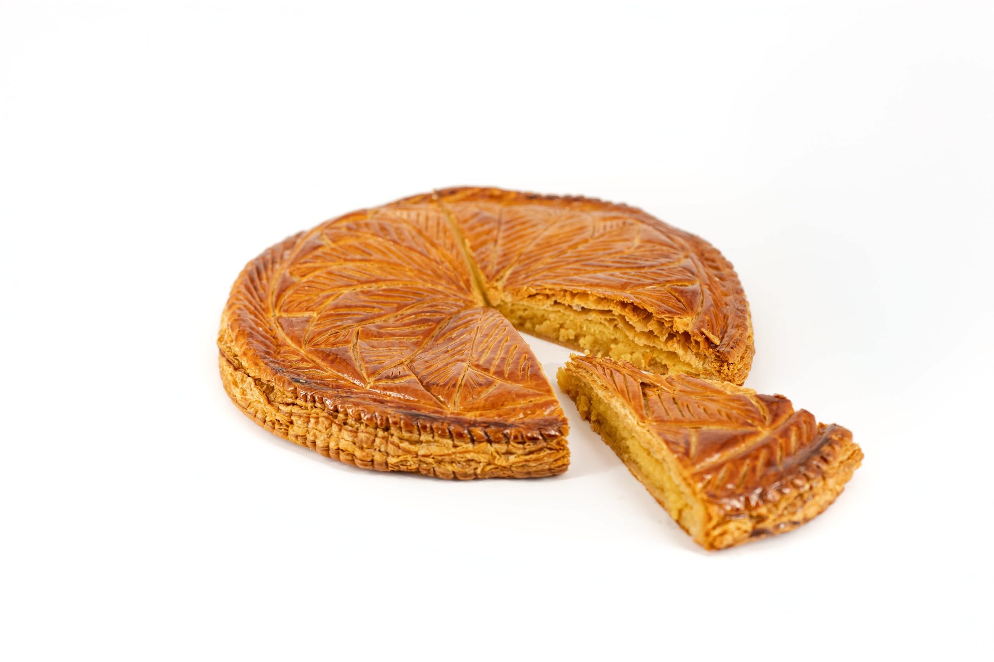 Galette des rois recette traditionnelle découpée d'une part sur fond blanc.