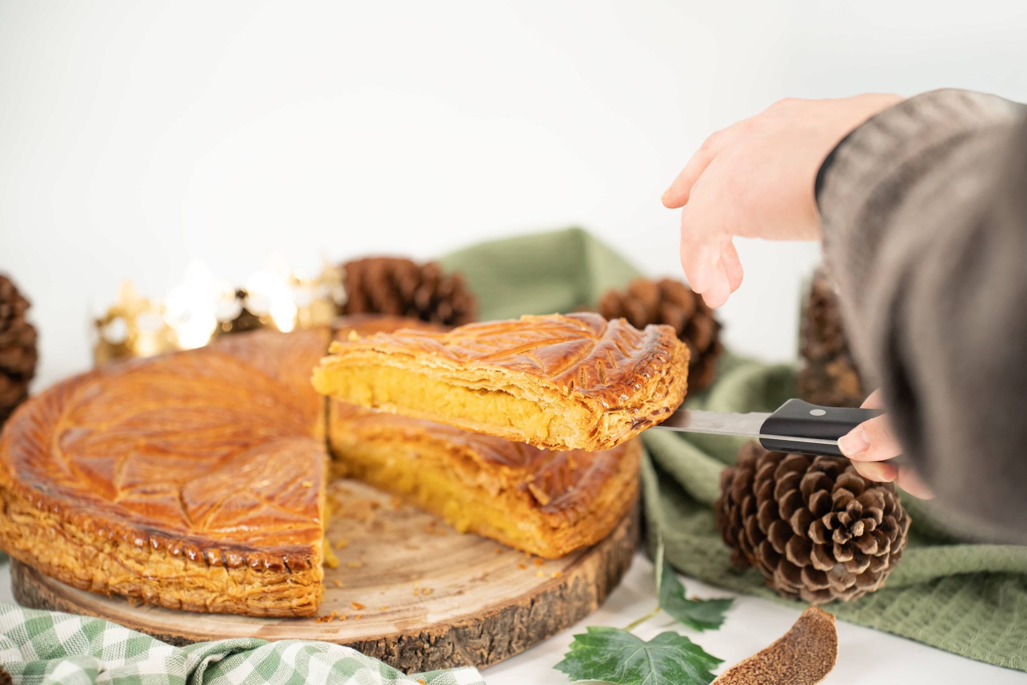 Galette des rois recette traditionnelle découpée d'une part en train d'être servit.